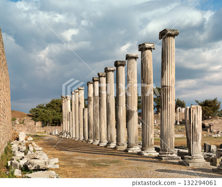 Row of ancient columns at Asklepion, Pergamon, Bergama, Turkey under a dramatic cloudy sky. Row of ancient columns at Asklepion, Pergamon, Bergama, Turkey under a dramatic cloudy sky. 132294061