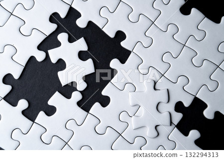 White jigsaw puzzle with missing piece and black background 132294313