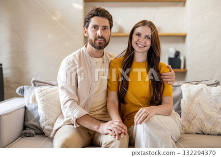 Couple sitting close to each other on a sofa at home and feeling peaceful 132294370