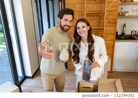 Couple feeling excited and happy while unpacking possessions in their new house Couple feeling excited and happy while unpacking possessions in their new house 132294382