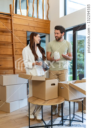 Couple feeling excited and happy while unpacking possessions in their new house Couple feeling excited and happy while unpacking possessions in their new house 132294385