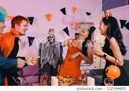 Joyful office Halloween party with coworkers in costumes, celebrating with drinks and laughter, fostering teamwork and festive spirit 132294605