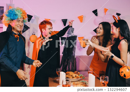Joyful office Halloween party with coworkers in costumes, celebrating with drinks and laughter, fostering teamwork and festive spirit 132294607
