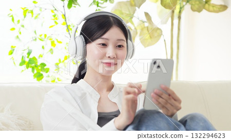 亞洲女性戴著無線耳機聽音樂 亞洲女性戴著無線耳機聽音樂 132294623