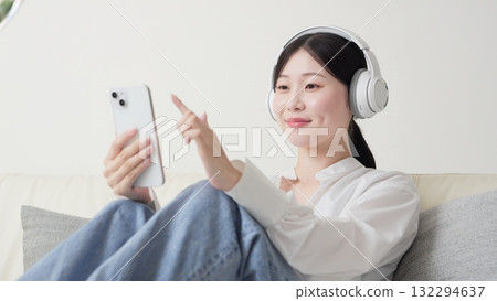 Asian woman listening to music with wireless headphones 132294637
