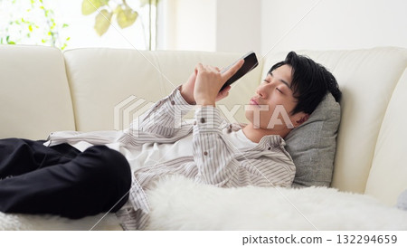 Asian man falling asleep while looking at his smartphone 132294659