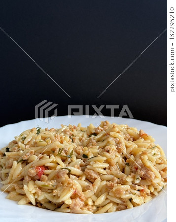 Orzo pasta dish with ground meat and tomato sauce. Plate of orzo pasta with meat sauce. Orzo pasta dish with ground meat and tomato sauce. Plate of orzo pasta with meat sauce. 132295210