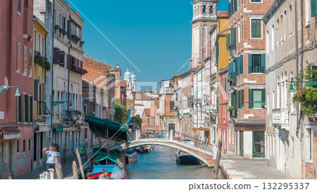 A view of Venice timelapse: canal, bridge, boats and an old tower in the background 132295337