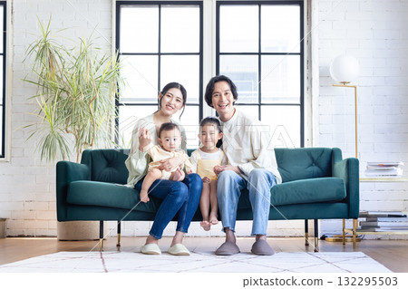 一個在客廳裡放鬆的年輕家庭 132295503