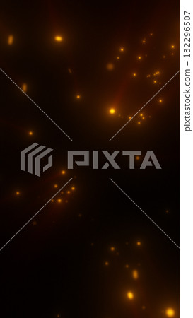 Golden glowing particles scattered on a dark background, creating a warm abstract bokeh effect 132296507