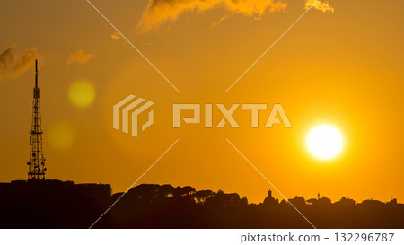 Rome at sunset timelapse with the fiery orb of the sun dropping below the horizon above the rooftops of the historical buildings 132296787