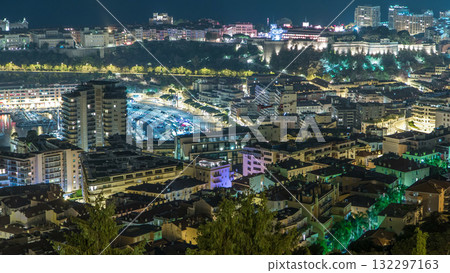 Cityscape of Monte Carlo, Monaco night timelapse with roofs of buildings and traffic on roads. 132297163