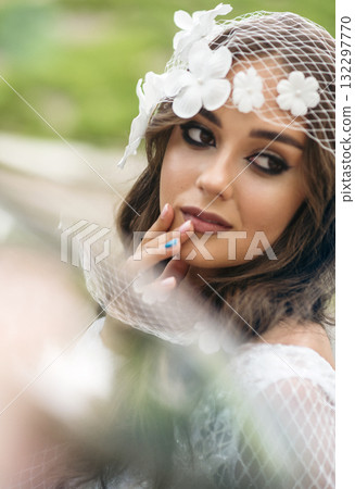 Profile portrait of a young woman with floral veil, showcasing natural beauty, smooth skin texture 132297770