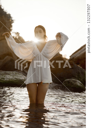A woman standing next to a body of water 132297807
