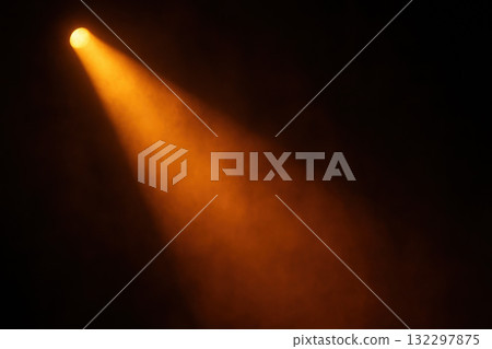 Orange stage spotlight beam cutting through dark atmosphere. Dramatic lighting for concert or theater creates mysterious and focused mood, highlighting an empty space 132297875