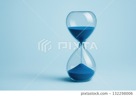 Blue hourglass with flowing sand on light blue background, contemplative concept of time passing. minimal and clean modern composition representing deadline or waiting 132298006