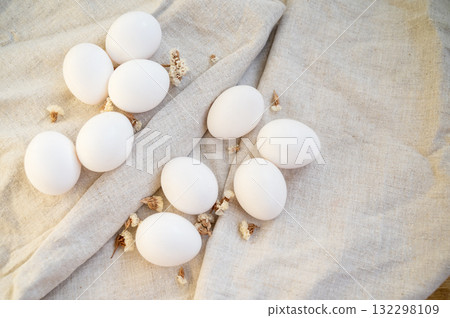 white eggs in a cardboard box, 10 pieces, on a surface made of natural materials. white eggs in a cardboard box, 10 pieces, on a surface made of natural materials. 132298109