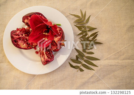 large red ripe pomegranate fruit and red flower 132298125