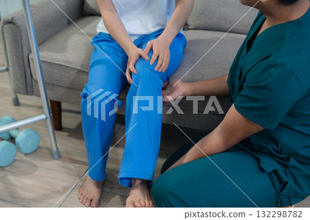 woman doing exercise at clinic with physiotherapist. help of a therapist trainer during a rehabilitation session. 132298782
