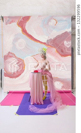 Elegant woman in Marie Antoinette dress serving red dessert on pastel abstract backdrop Elegant woman in Marie Antoinette dress serving red dessert on pastel abstract backdrop 132299596