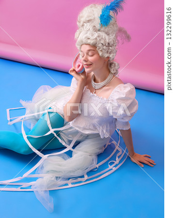 Smiling woman in white dress as Marie Antoinette with headphones on colorful background. Smiling woman in white dress as Marie Antoinette with headphones on colorful background. 132299616