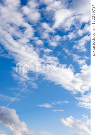 clear blue sky with white fluffy clouds. vertical nature background. soft cumulus cloudscape wallpaper on a bright day. fresh air due to reduced emission in summer atmosphere clear blue sky with white fluffy clouds. vertical nature background. soft cumulus cloudscape wallpaper on a bright day. fresh air due to reduced emission in summer atmosphere 132299754