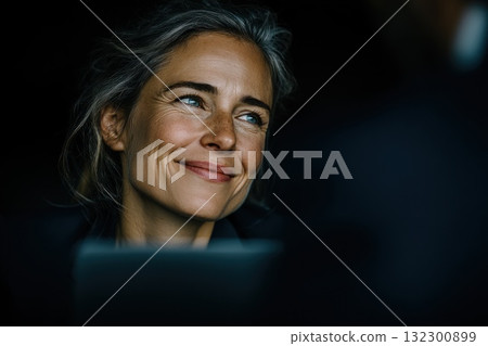 Woman smiles while engaging in a thoughtful discussion with a colleague in a bright office setting 132300899
