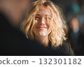Bright smile of a young woman in a bustling city setting fills the scene with positivity and warmth 132301182