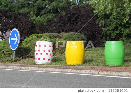 Barrels with the colors of the Tour de France leader's jerseys at a roundabout 132301691