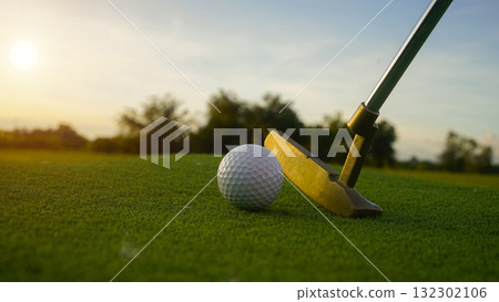 Golf clubs and balls on a green lawn in a beautiful golf course with morning sunshine. 132302106
