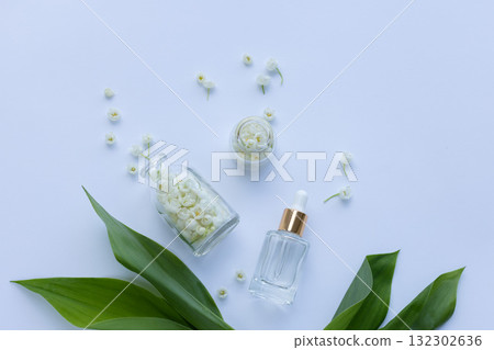 Glass bottle of lily of the valley essential oil with fresh flowers Glass bottle of lily of the valley essential oil with fresh flowers 132302636