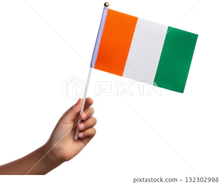 一個孩子的手拿著一面科特迪瓦小國旗。 一個孩子的手拿著一面科特迪瓦小國旗。 132302998