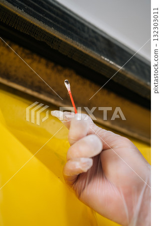 Vertical cropped shot of technician in gloves cleaning mold from dirty air conditioner with cotton swab, promoting proper hygiene and ensuring effective maintenance for improved indoor air quality. 132303011