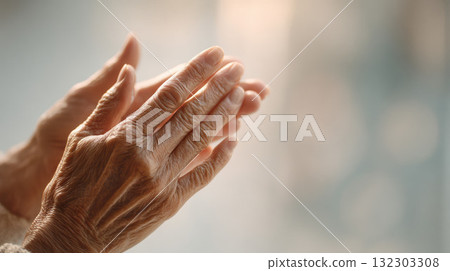 Close-up of the hands of an elderly woman applauding. A senior person with wrinkled hands clapping, expressing gratitude, support, or celebration with a warm, gentle touch Close-up of the hands of an elderly woman applauding. A senior person with wrinkled hands clapping, expressing gratitude, support, or celebration with a warm, gentle touch 132303308