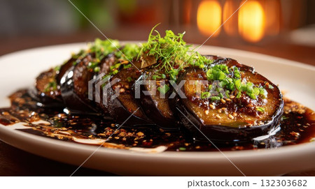Glazed eggplant slices with sesame seeds, scallions, and microgreens on a white plate in warm restaurant lighting, perfect for Asian cuisine concepts Glazed eggplant slices with sesame seeds, scallions, and microgreens on a white plate in warm restaurant lighting, perfect for Asian cuisine concepts 132303682