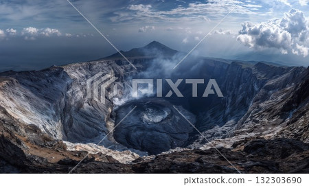 Active volcanic crater with steaming sulfur deposits and dramatic mountainous landscape under cloudy sky showcasing raw geological power and natural formation 132303690