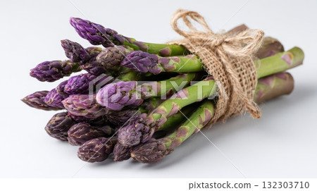 Bundle of fresh purple asparagus spears tied with natural burlap string on white background, ideal for organic farm produce, healthy vegetable, and gourmet cooking themes 132303710