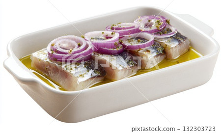 Raw herring fillets marinated with red onion rings and olive oil in white dish, classic European appetizer preparation for traditional pickled fish recipe 132303723