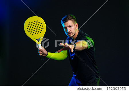 Skilled player prepares to serve in a vibrant indoor paddle tennis match Skilled player prepares to serve in a vibrant indoor paddle tennis match 132303953