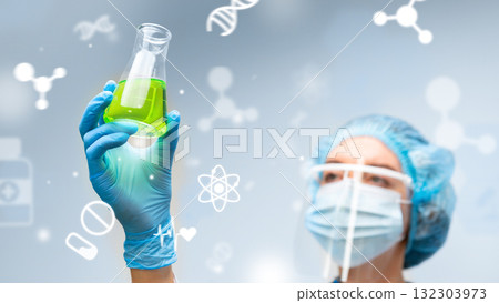 Scientist examines green liquid in laboratory setting during research on new compounds 132303973