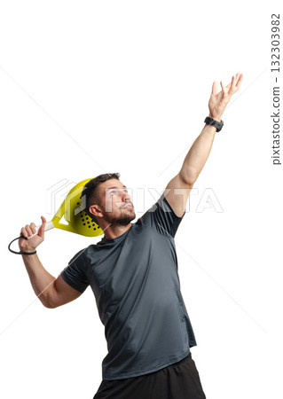 Man practicing tennis serve indoors with a paddle in a bright setting during the day 132303982