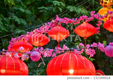 Close-up of the traditional Chinese red lantern with outdoor starry solar string lights. Big red lantern. Festive decoration. Mid-autumn festival, Chinese New Year decoration for celebration. Close-up of the traditional Chinese red lantern with outdoor starry solar string lights. Big red lantern. Festive decoration. Mid-autumn festival, Chinese New Year decoration for celebration. 132304028