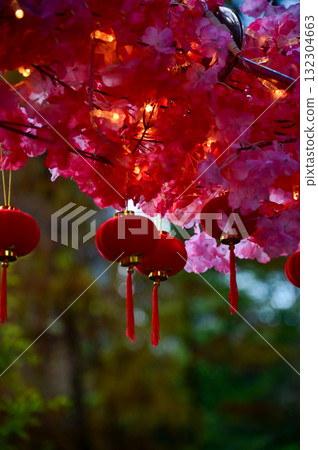 Close-up of the Chinese traditional red lantern decor with artificial peach blossom flower in outdoors. Festive decoration and celebration. Chinese New Year decoration. For background use. 132304663