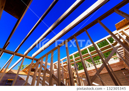 Workers are constructing wooden frame of new house in neighborhood. Workers are constructing wooden frame of new house in neighborhood. 132305345