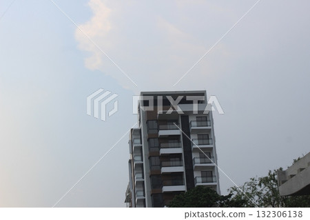 Modern apartment building with balconies against a cloudy sky, showcasing urban architecture and residential living Modern apartment building with balconies against a cloudy sky, showcasing urban architecture and residential living 132306138