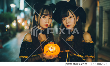 Two people in costumes and a pumpkin lantern in the city on an autumn night Two people in costumes and a pumpkin lantern in the city on an autumn night 132306325