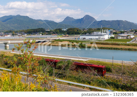 The Heisei Chikuho Railway's "Cotokoto Train" overlooking Mount Fukuchi along the Hikosan River The Heisei Chikuho Railway's "Cotokoto Train" overlooking Mount Fukuchi along the Hikosan River 132306365