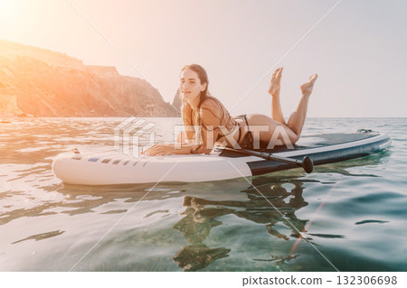 Woman Paddleboarding Ocean Coastline Relaxing on Inflatable SUP Board - Summer Vacation Adventure Woman Paddleboarding Ocean Coastline Relaxing on Inflatable SUP Board - Summer Vacation Adventure 132306698