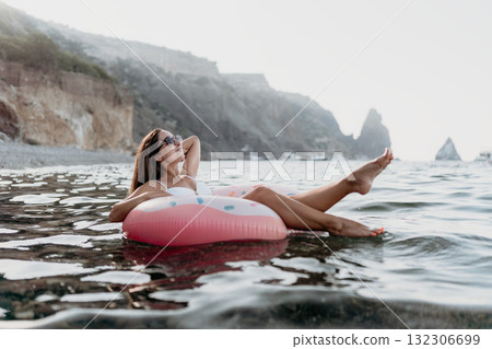 Woman, relaxing, sea. Young woman in white swimsuit floats on an inflatable ring, enjoying summer vacation. Woman, relaxing, sea. Young woman in white swimsuit floats on an inflatable ring, enjoying summer vacation. 132306699
