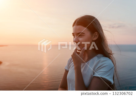 Teenage Girl Gazing at Sunset Over the Ocean Teenage Girl Gazing at Sunset Over the Ocean 132306702